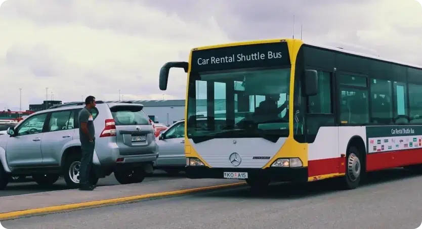 Car rental shuttle bus at KEF Airport, providing free transportation for travelers to begin their Iceland road trip.