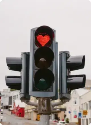 Feu de signalisation en Islande avec un signal rouge en forme de cœur, ajoutant une note de charme à la rue de la ville.