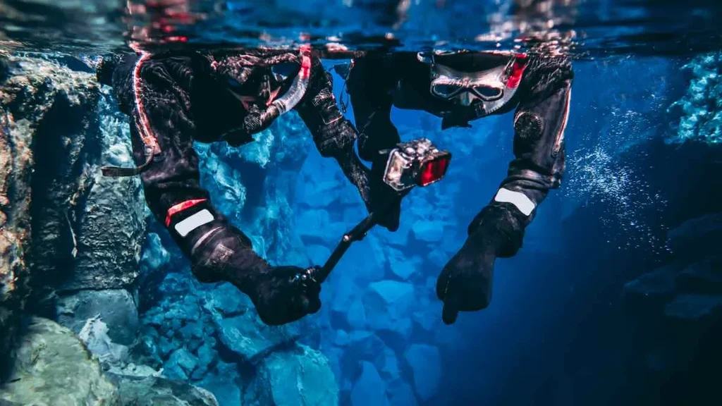 Divers exploring the crystal-clear waters of the Silfra Fissure in Iceland, capturing the underwater beauty and the unique experience of diving between tectonic plates.