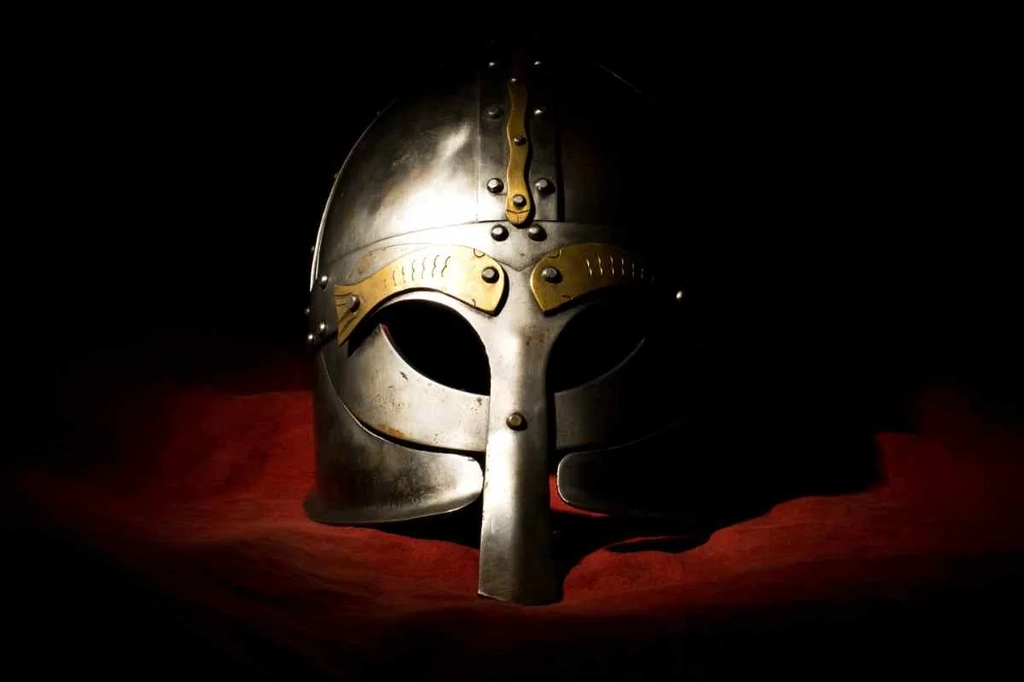 A dramatic, dimly lit Viking helmet on a dark background, highlighting the historical and cultural significance of the Viking era in Iceland.