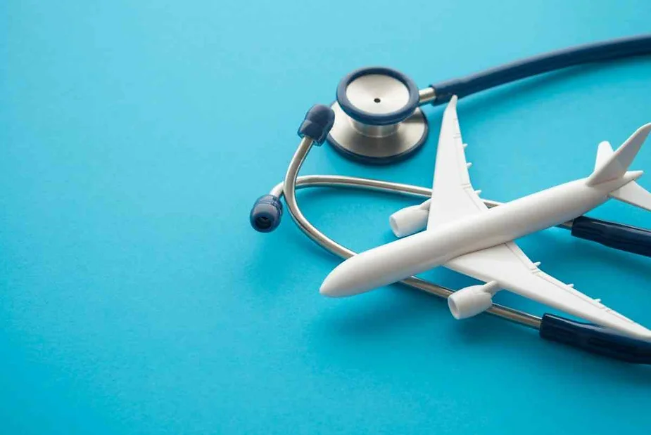 A stethoscope and a toy airplane on a blue background.