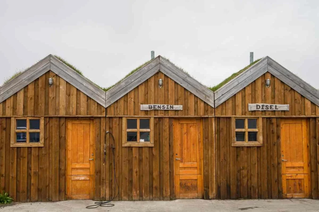 Traditional Icelandic wooden gas station with separate sections for gasoline (Bensín) and diesel (Dísel) fuel.