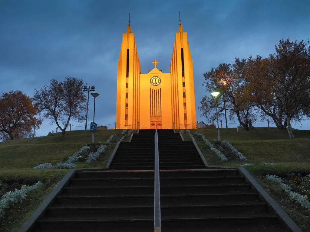 The stunning Akureyri Church illuminated at dusk, standing majestically with a staircase leading up to it in Akureyri, Iceland.