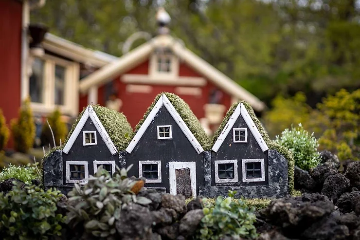 A delightful elf house nestled in the greenery of Iceland, capturing the magical and whimsical essence of Icelandic folklore.