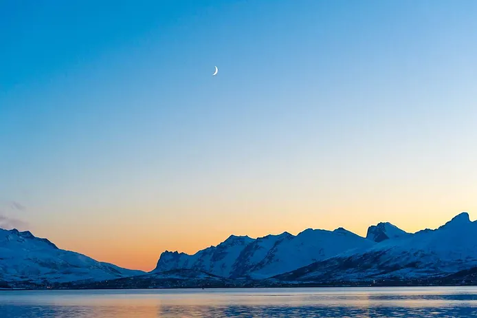 Midnight sun setting in a mountainous landscape