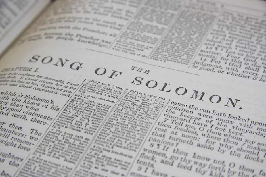 Close-up of an open Bible showing the text of the Song of Solomon, highlighting the ancient biblical poetry and wisdom.