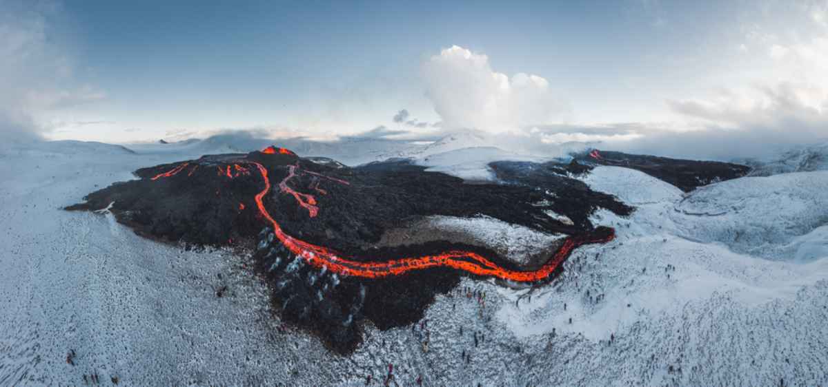 Iceland volcano eruption with red-hot lava and snow surrounding it