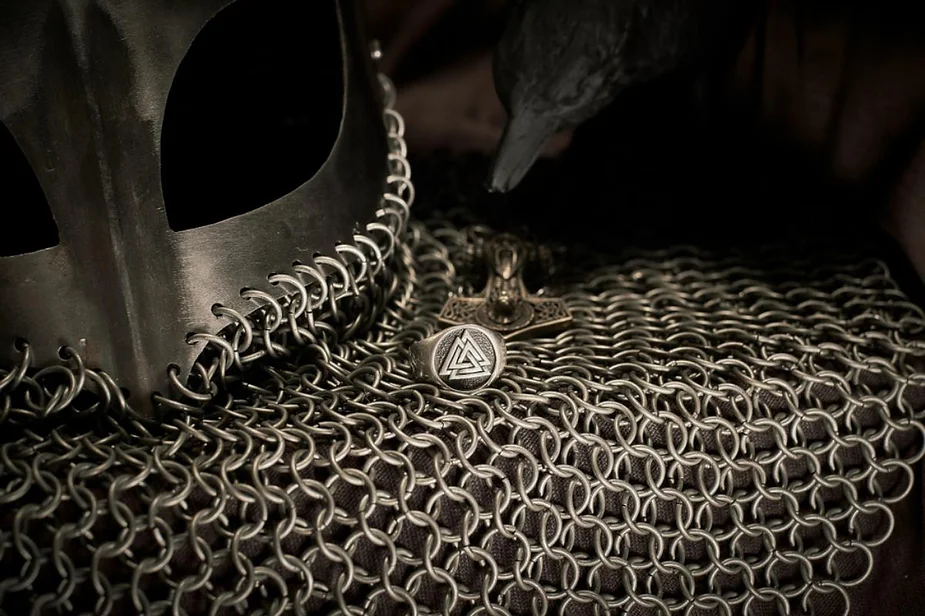 Viking chainmail armor with a helmet, a Thor's hammer pendant, and a Valknut symbol ring.