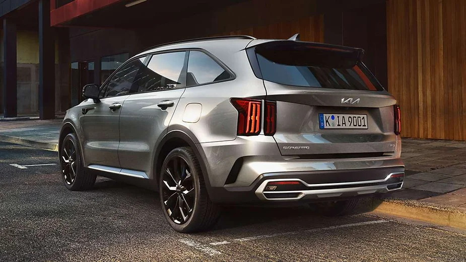 Rear view of a sleek and modern SUV parked on a city street, showcasing its stylish design, sharp taillights, and metallic finish.