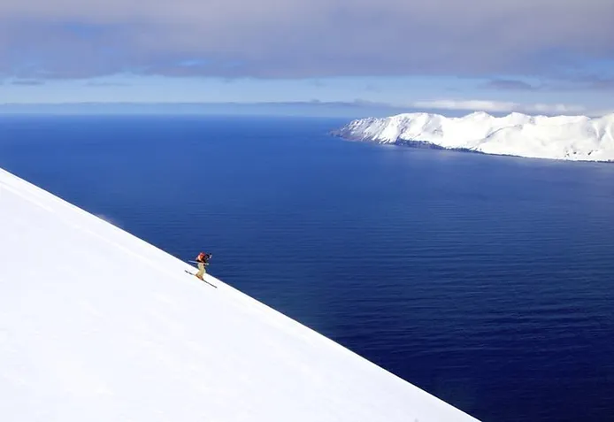 Skier heading down a hill in Iceland in winter