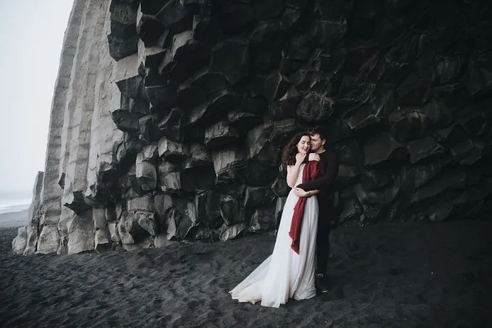 Groom and bride at the black sand beach of Iceland