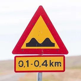 Speed bumps warning sign in Iceland indicating 0.1-0.4 km distance