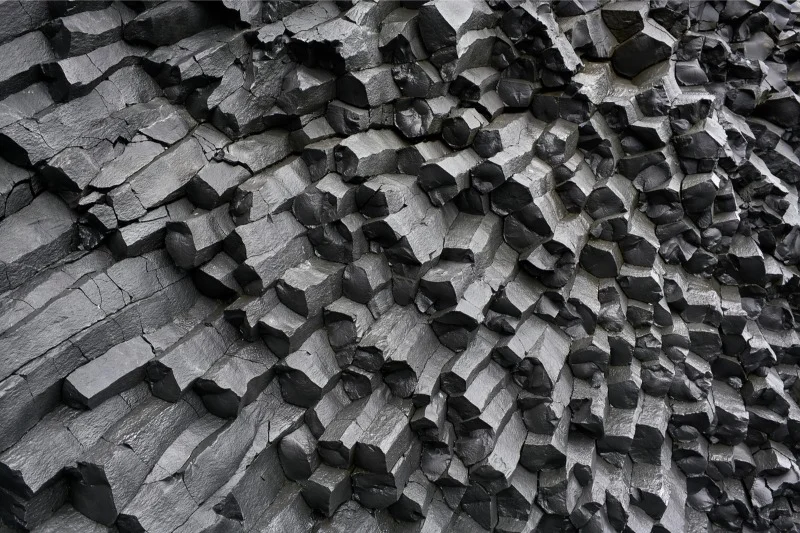 Close-up of hexagonal basalt columns at Reynisfjara Beach in Iceland, showcasing the unique geological formations and textures of the volcanic rock