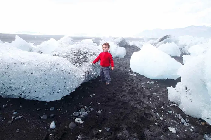 toddler standing by some icebergs