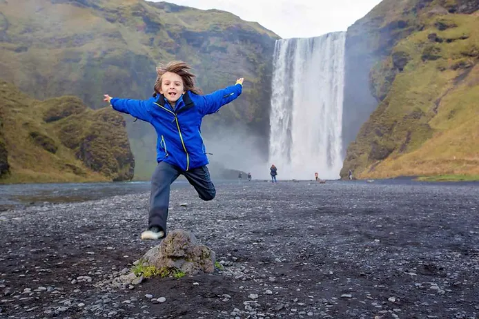 Child by Skogafoss waterfall, Iceland