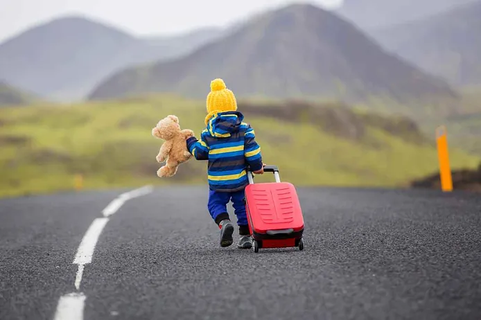 Kid with a suitcase for a trip to Iceland