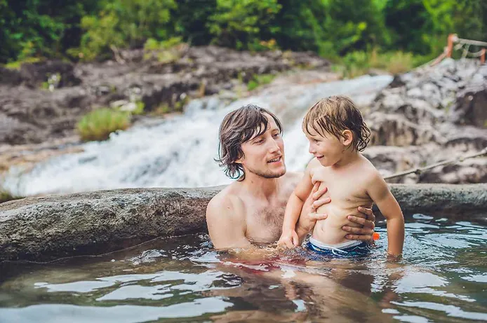 Father and son enjoying geothermal spring waters