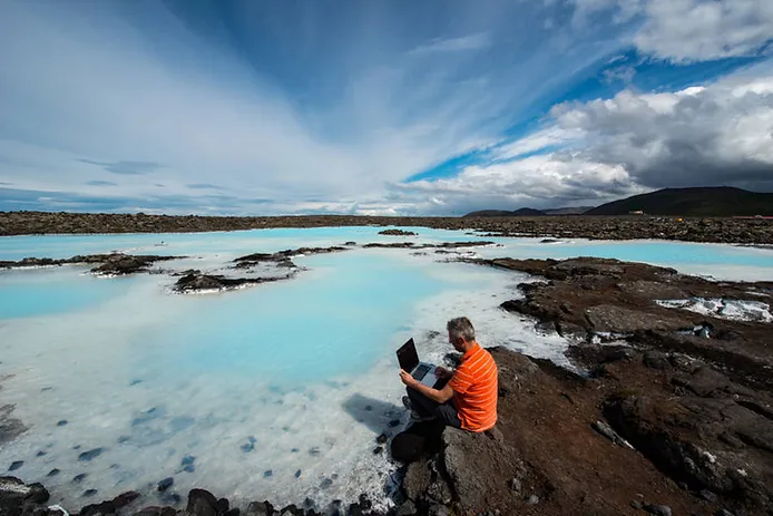 man working remotely with his laptop close to a geothermal area in Iceland