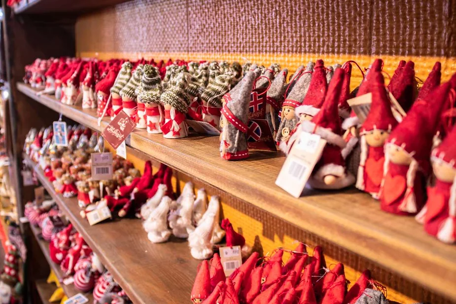 Rows of handcrafted Christmas decorations, including Icelandic Yule Lads and other festive ornaments, displayed on wooden shelves