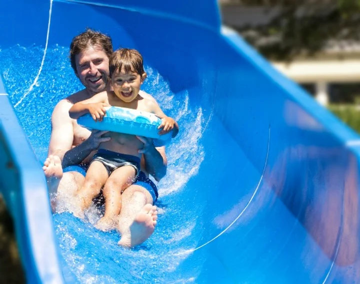 Father and son sliding down a waterslide