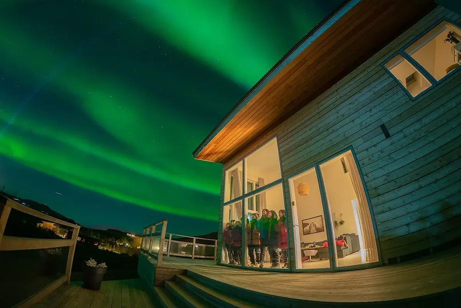 Modern luxury cabin near Mosfellsbær, Iceland, with glass windows offering Northern Lights views and a geothermal hot tub in a scenic setting.