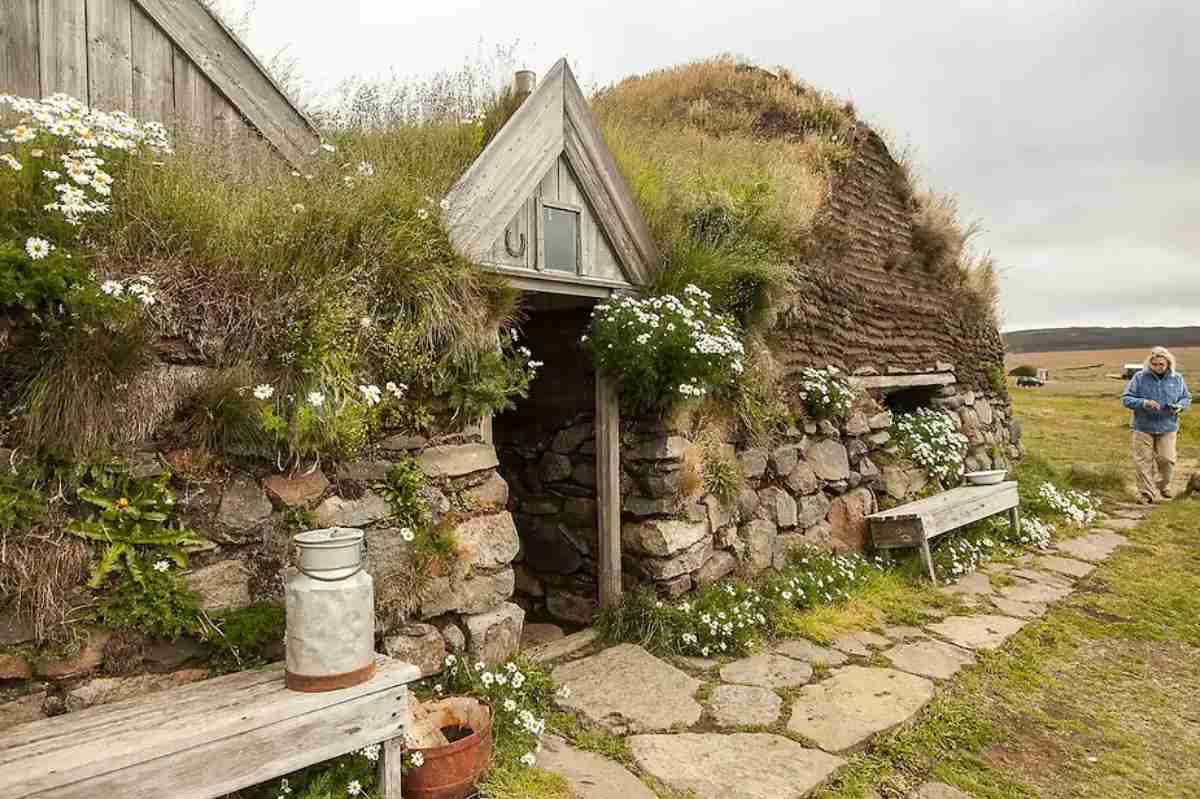 Historic Icelandic turf house, Sænautasel, near Egilsstaðir, offering a traditional candlelit experience with a cozy wood stove and attic sleeping area.