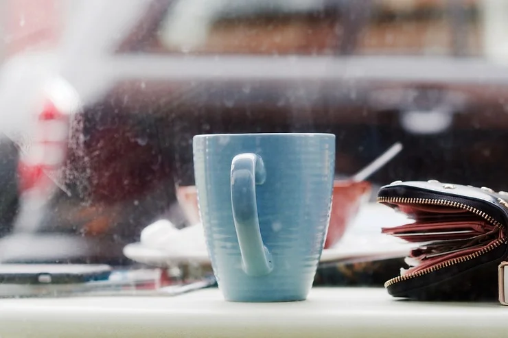 A blue coffee cup placed on a table in a cozy Icelandic coffee shop with a blurred background.