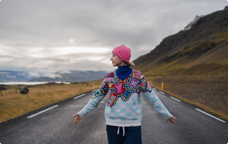 Viaggiatore sulla strada islandese che indossa diversi strati di abbigliamento