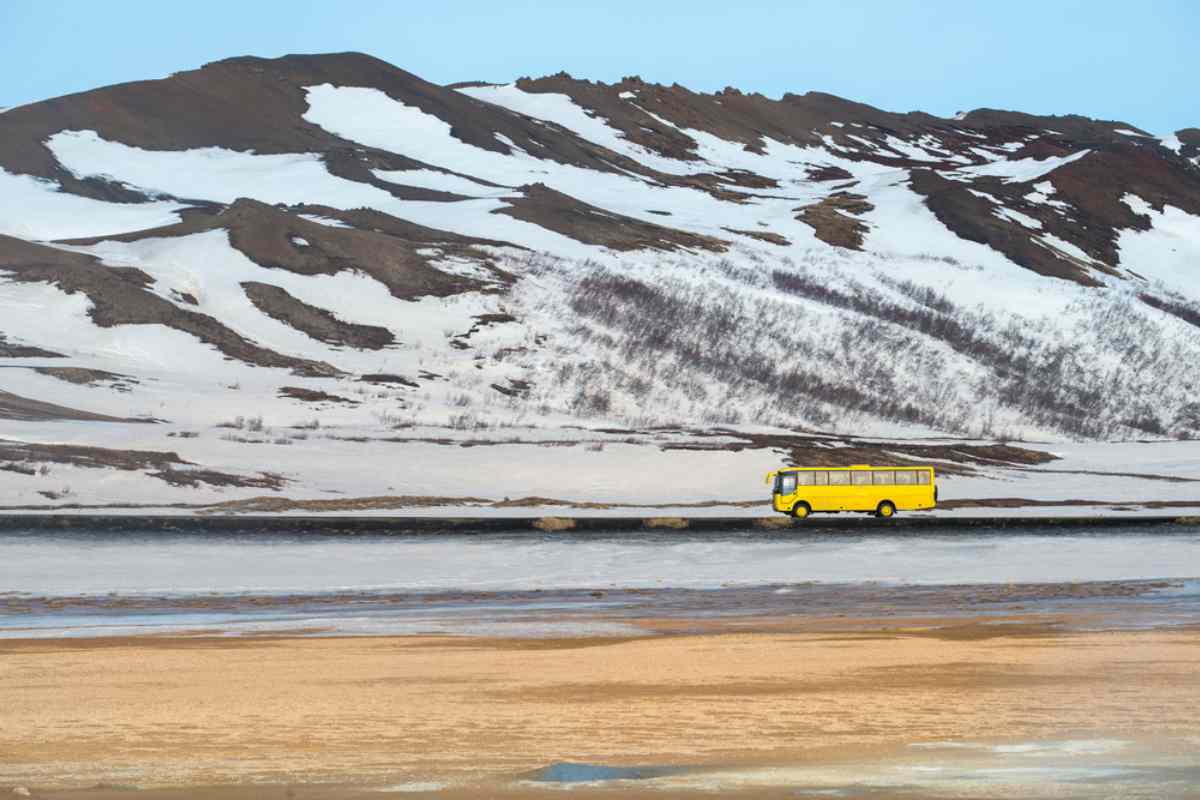 yellow coach bus traveling across Iceland