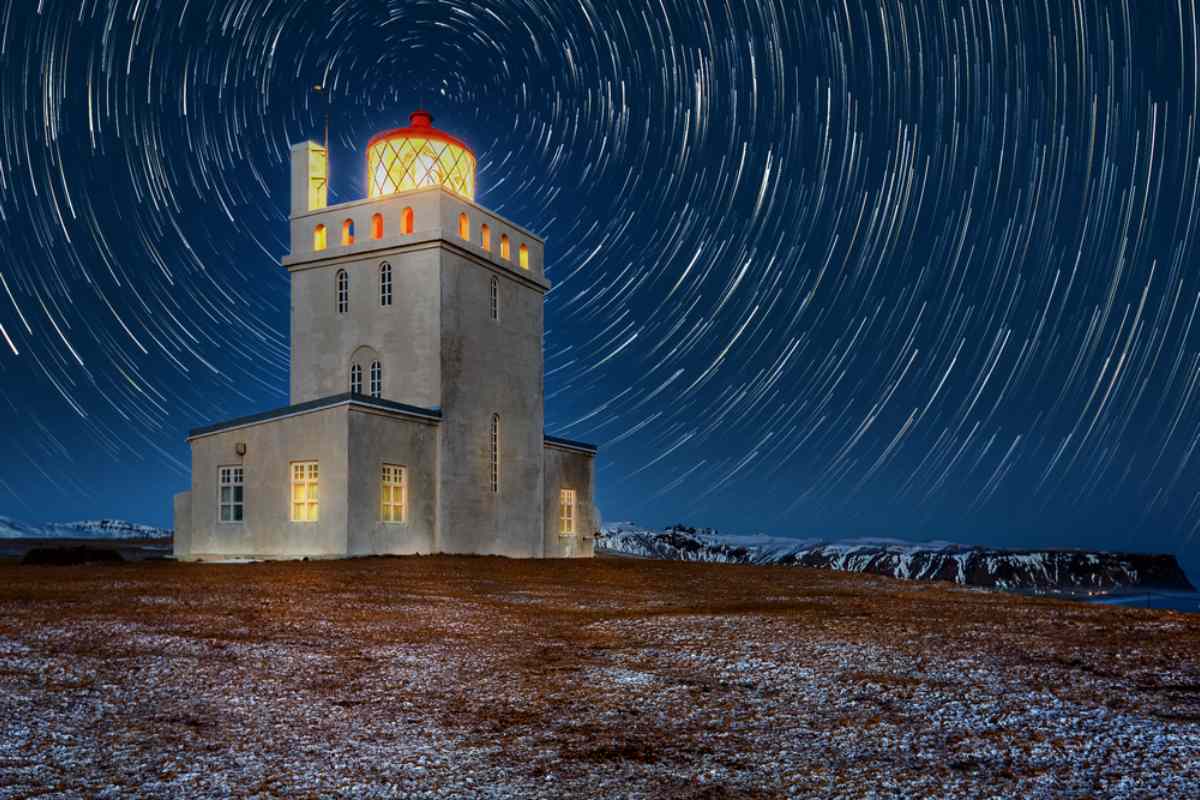 Concrete lighthouse with a starrry sky