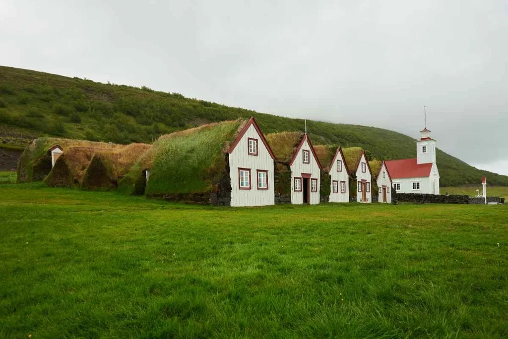 Traditional Icelandic turf houses at Laufás, showcasing unique architectural adaptation with steep, grass-covered roofs.