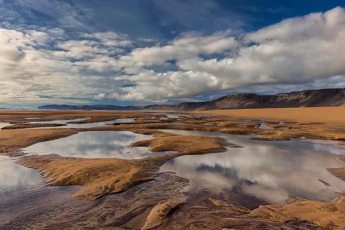 Rauðisandur beach with rugged mountain on the background and several clouds in the sky