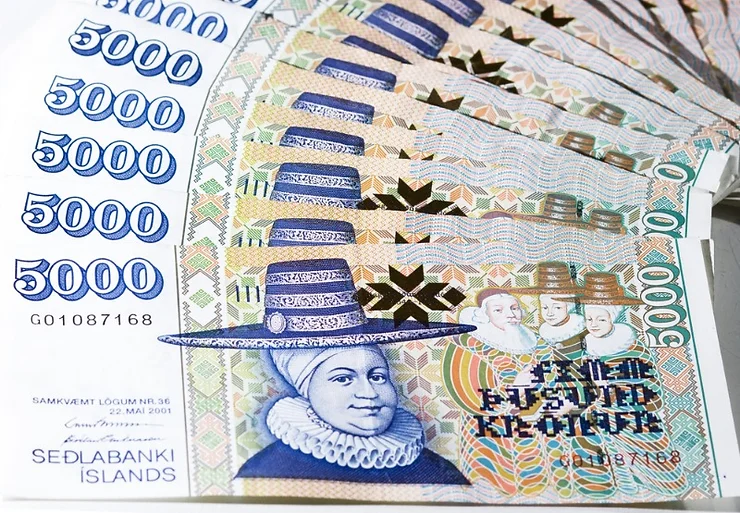 A stack of 5000 Icelandic Krona banknotes, featuring a prominent historical figure and intricate designs.