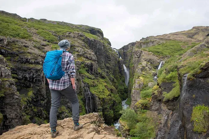 Hiker enjoying the views to Glymur waterfall