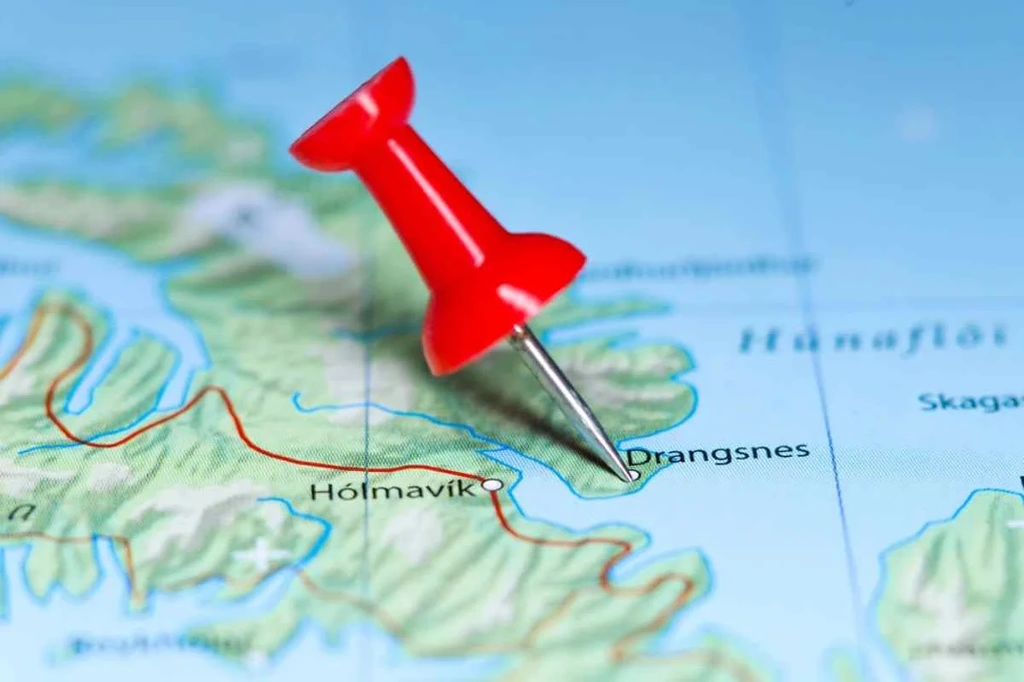 A close-up view of a map focusing on the town of Drangsnes in Iceland. A red pushpin marks the location of Drangsnes, indicating it as a point of interest. The map displays surrounding areas, including the nearby town of Hólmavík and the geographical features of the region. The image captures the Westfjords area of Iceland, known for its rugged landscapes and scenic beauty.