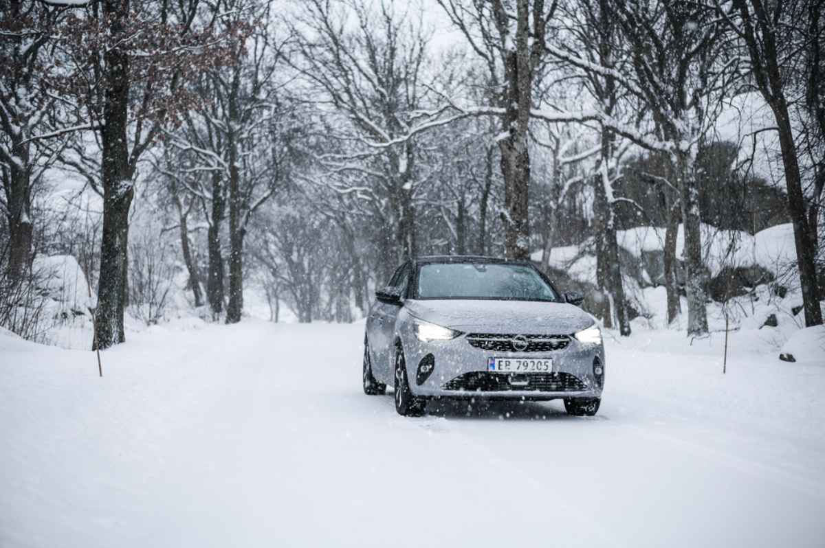 Opel Corsa Electric mitten in einem verschneiten Wald geparkt