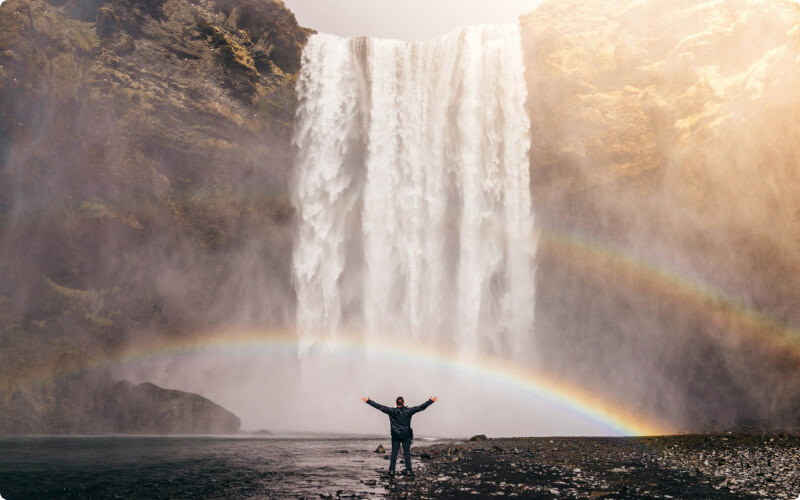 Touriste profitant de la chute d'eau de Skogafoss en Islande