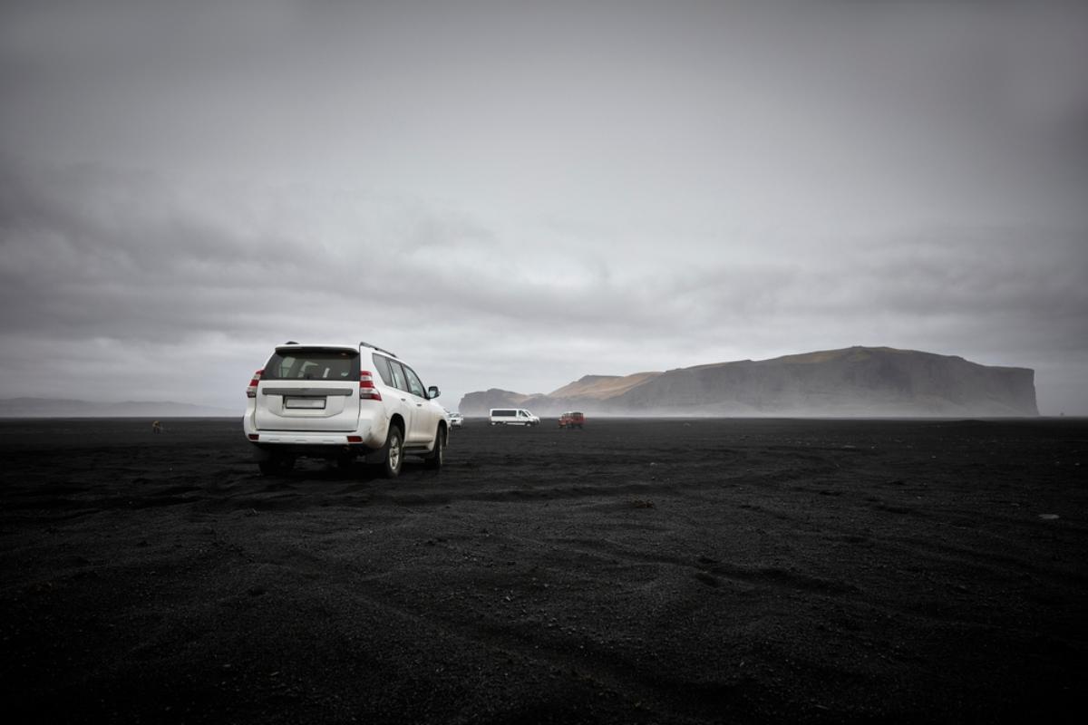 Véhicule SUV sur une route couverte de cendres volcaniques noires